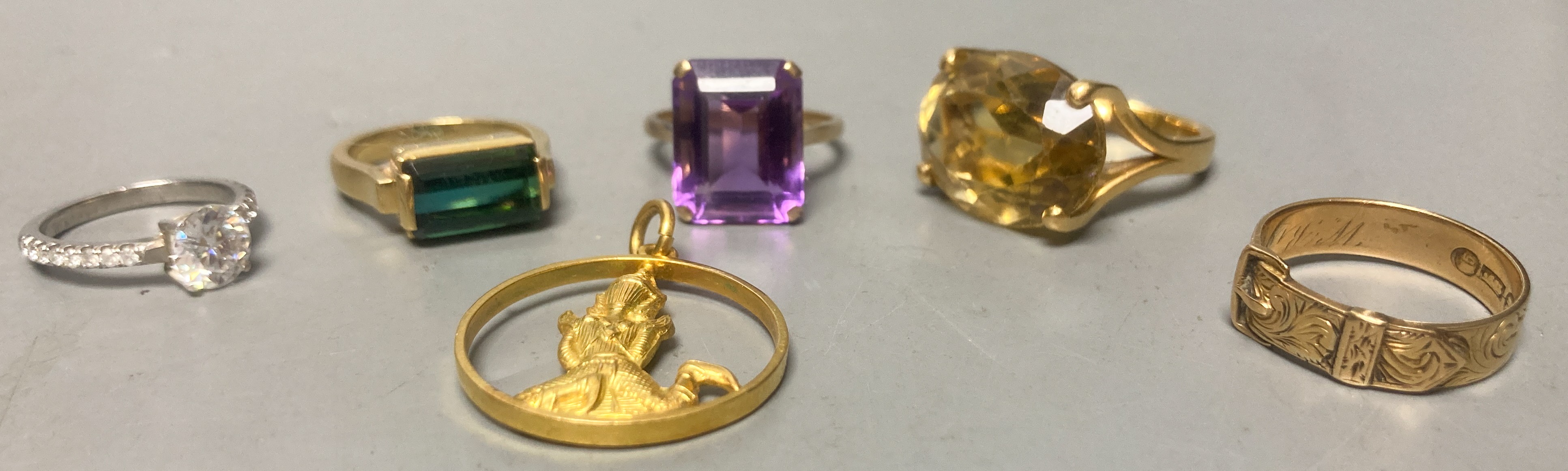 A Victorian 15ct gold buckle ring, size P/Q, 4.2 grams, three yellow metal and gem set dress rings, including amethyst, citrine and green tourmaline, gross 21.1 grams, an 18k deity pendant, 3.1 grams and a white metal an